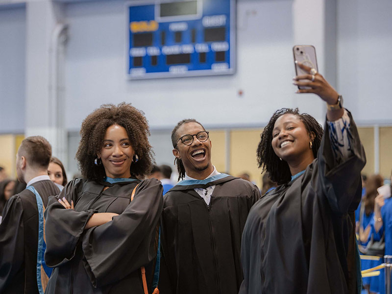 Three graduates posing for a selfie at Convocation.