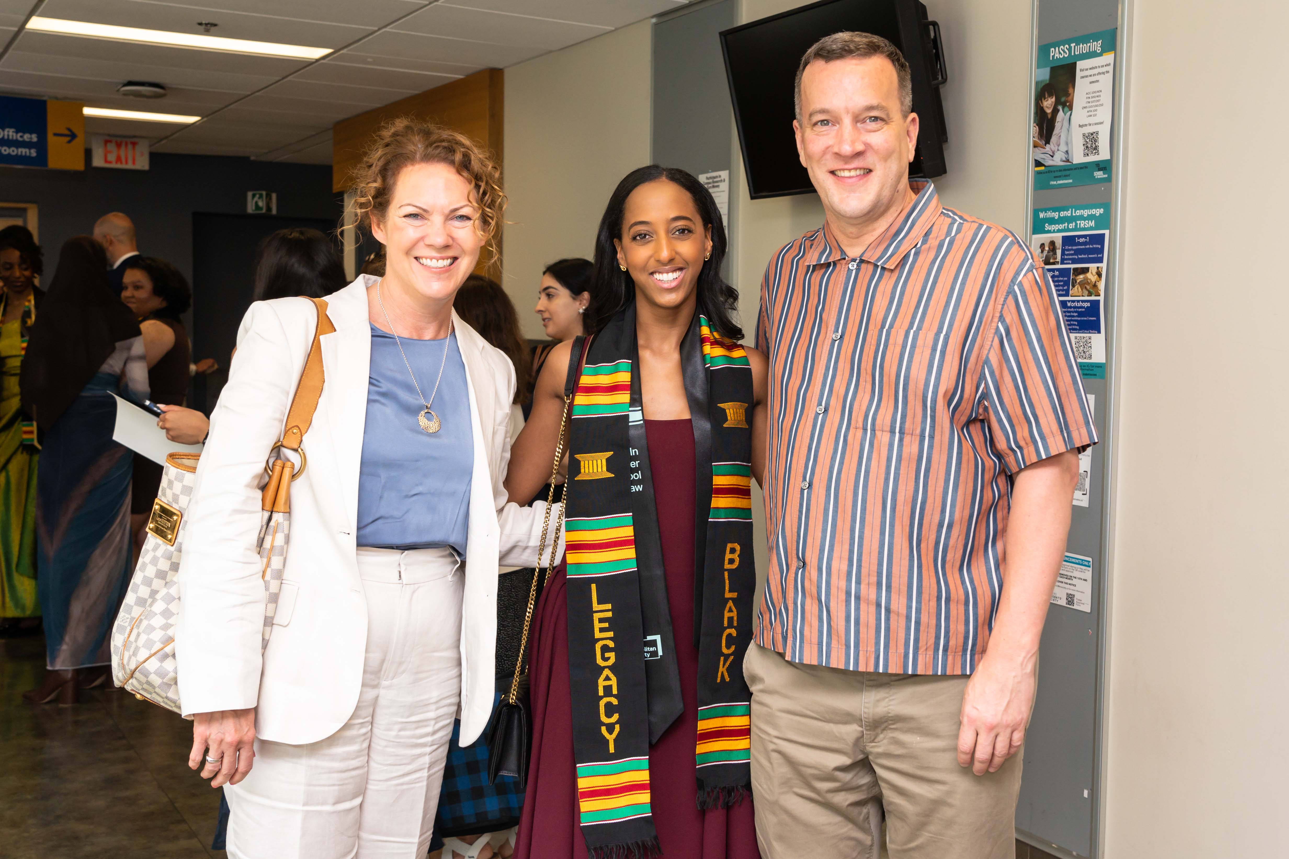 grad poses for photo with guests
