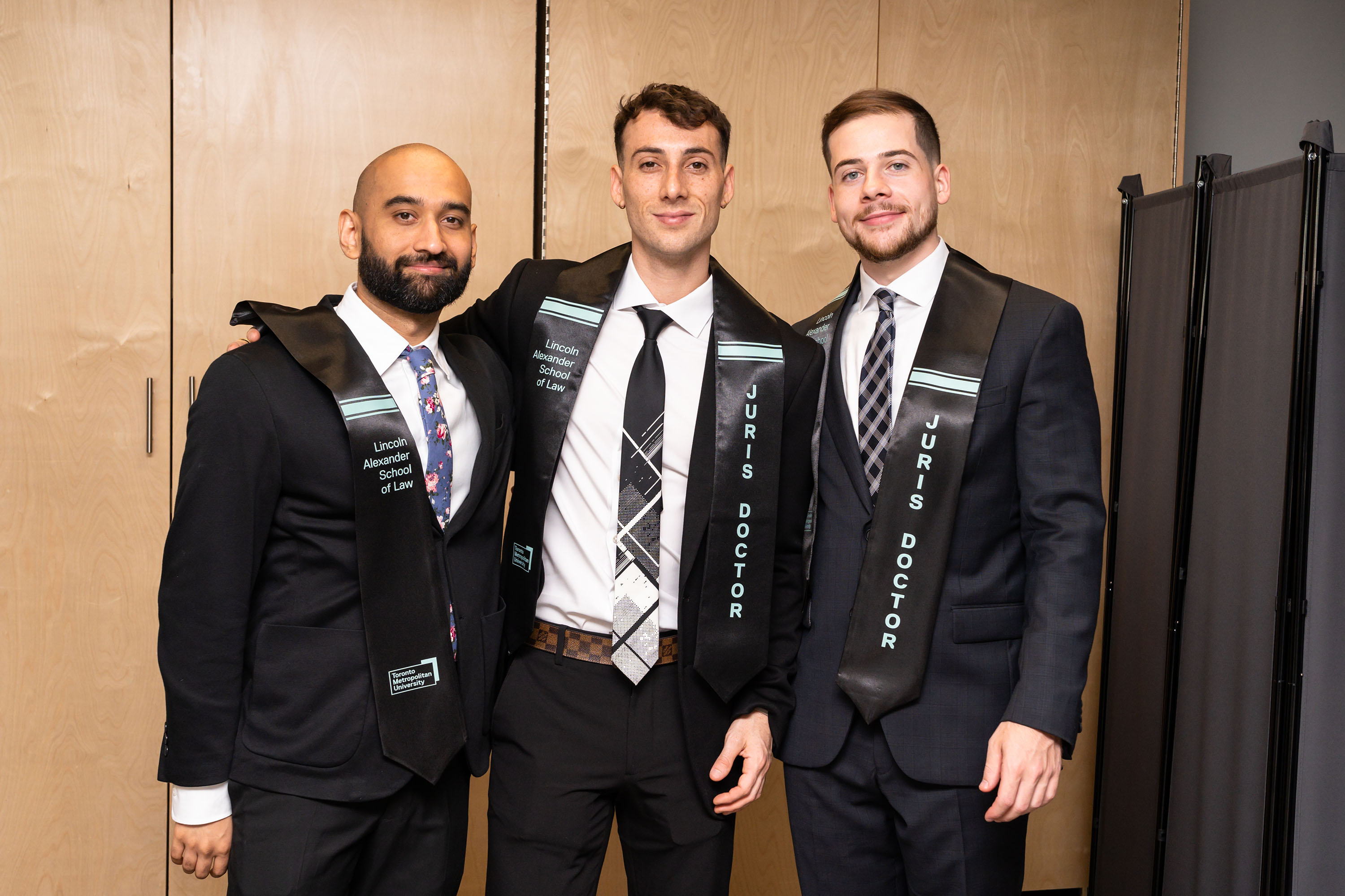 three grads pose for a photo
