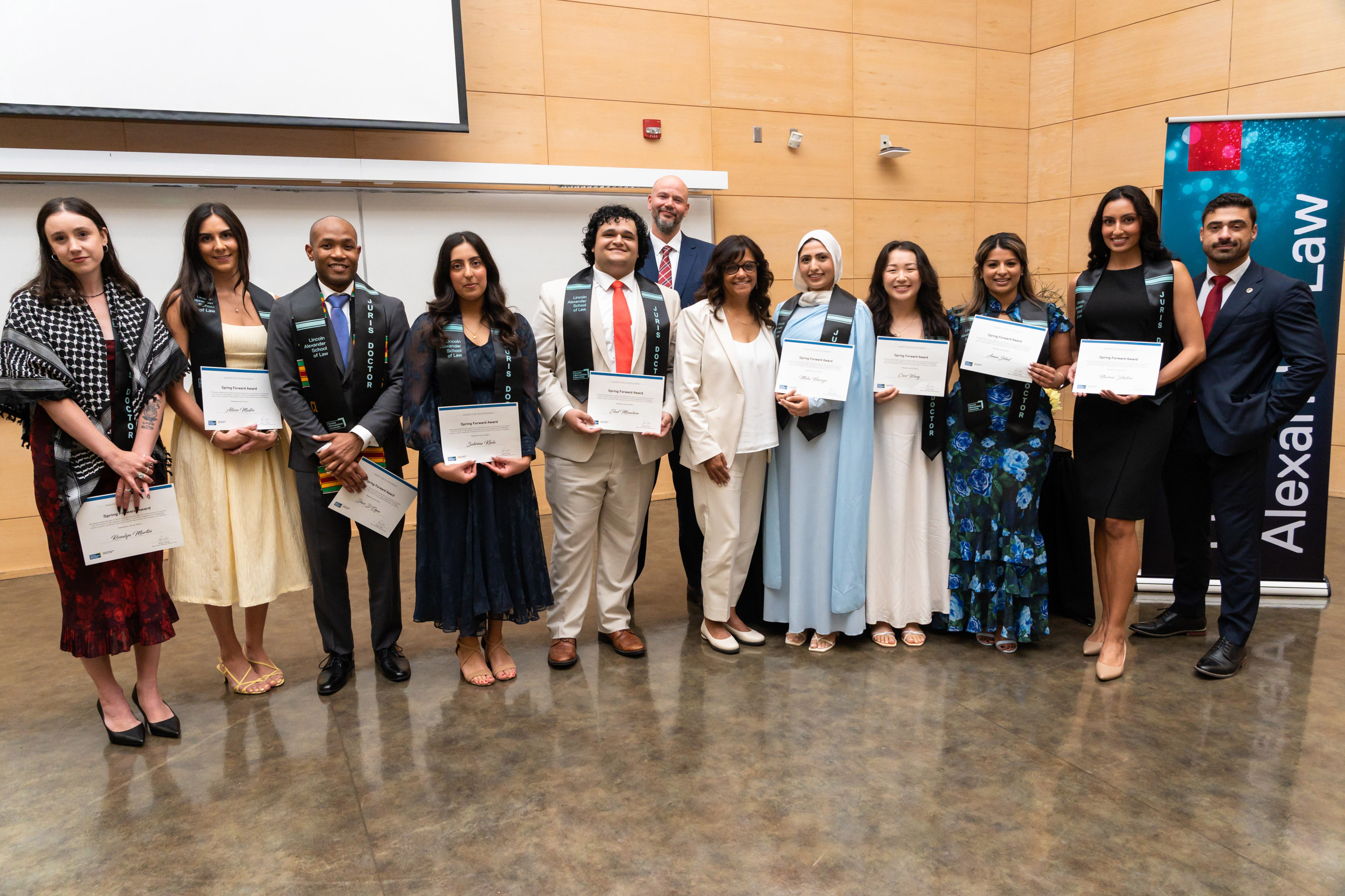 group posing with their degrees at the celebration