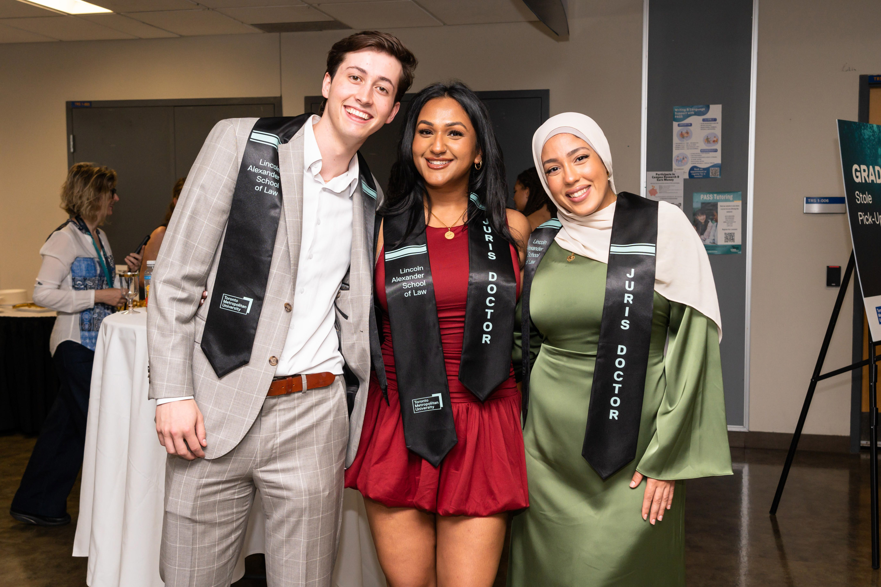 one male and two women pose at the grad celebration