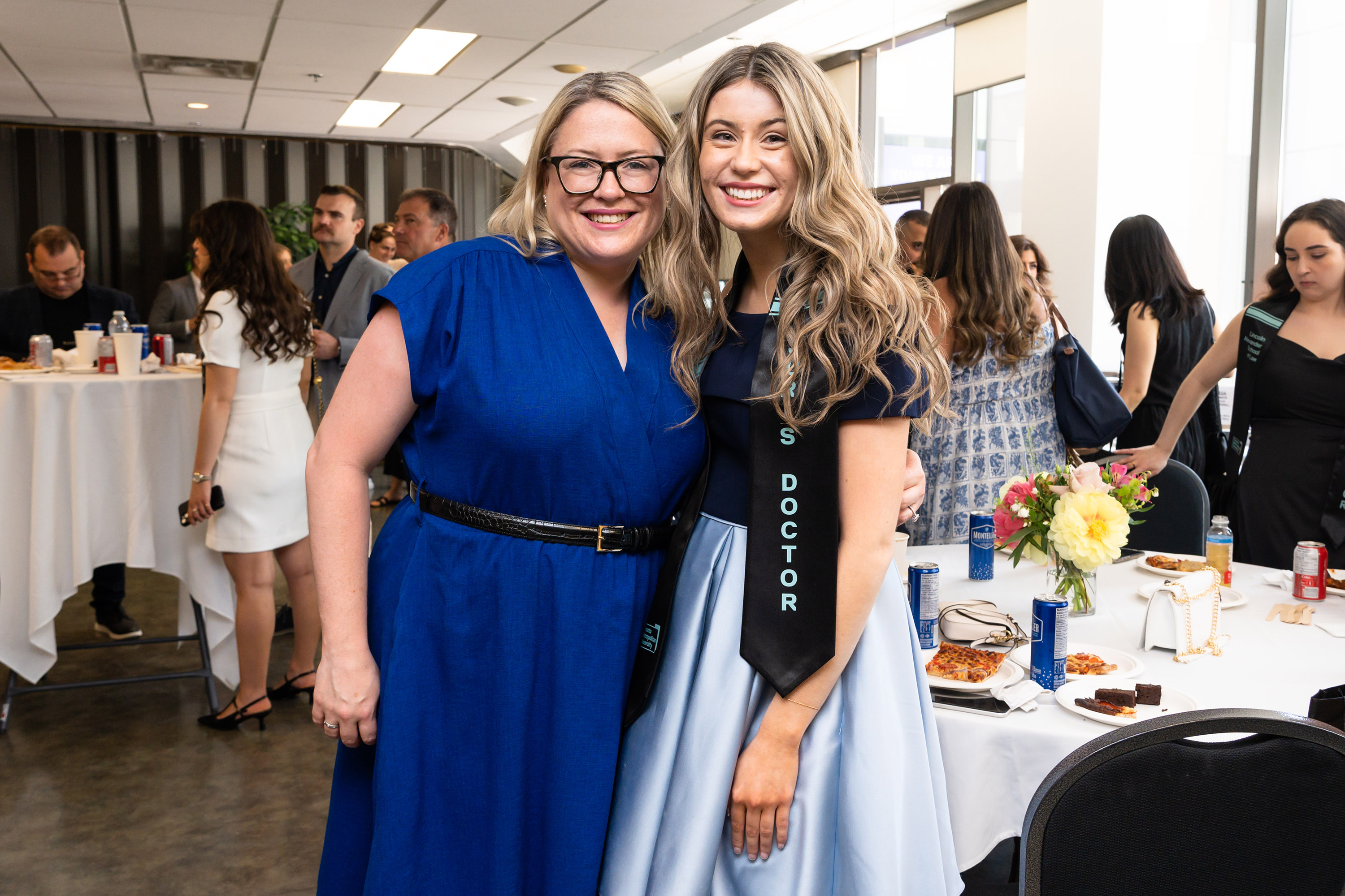 faculty mermber and grad pose at celebration