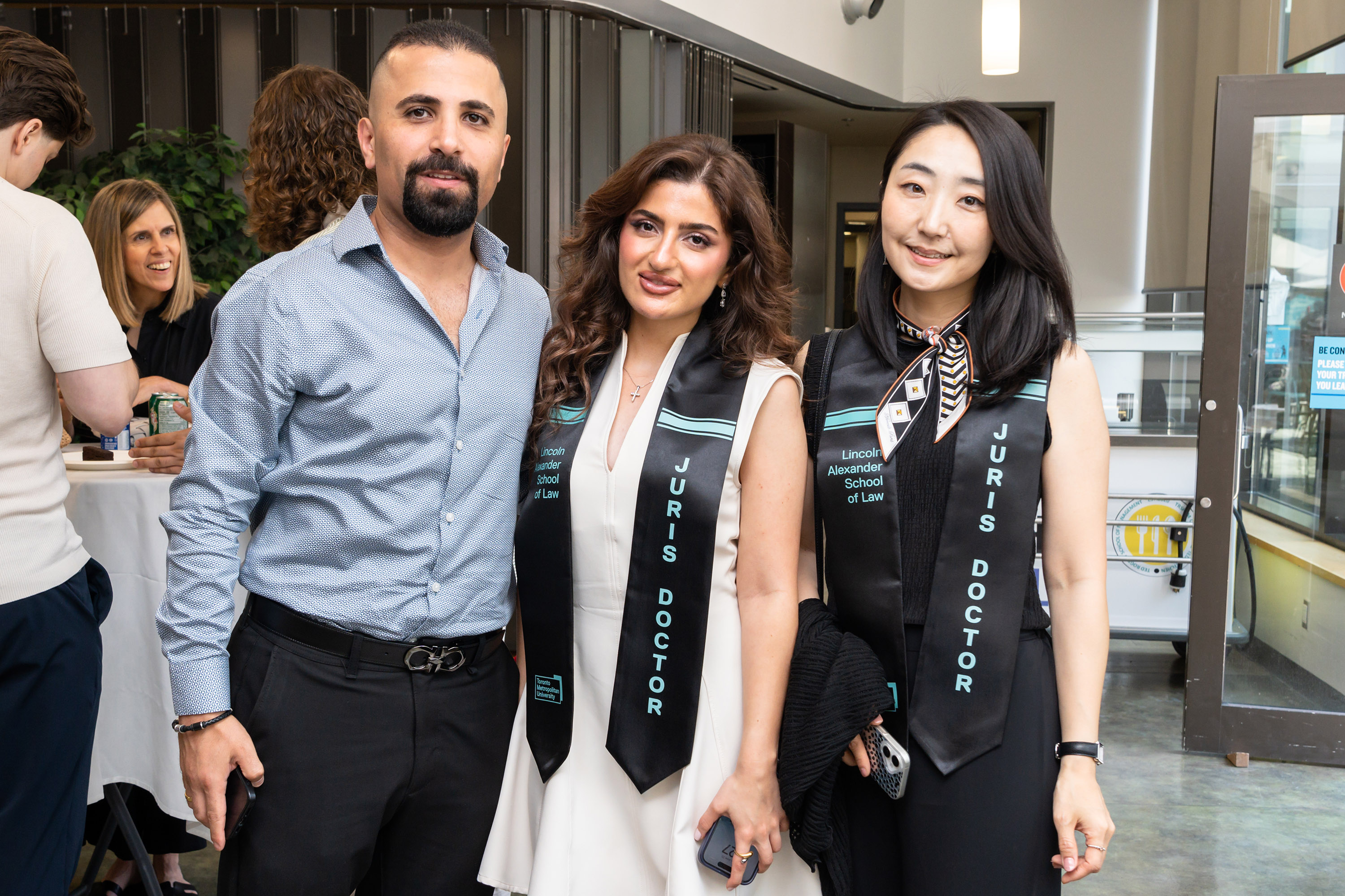 two women and a man pose at celebration