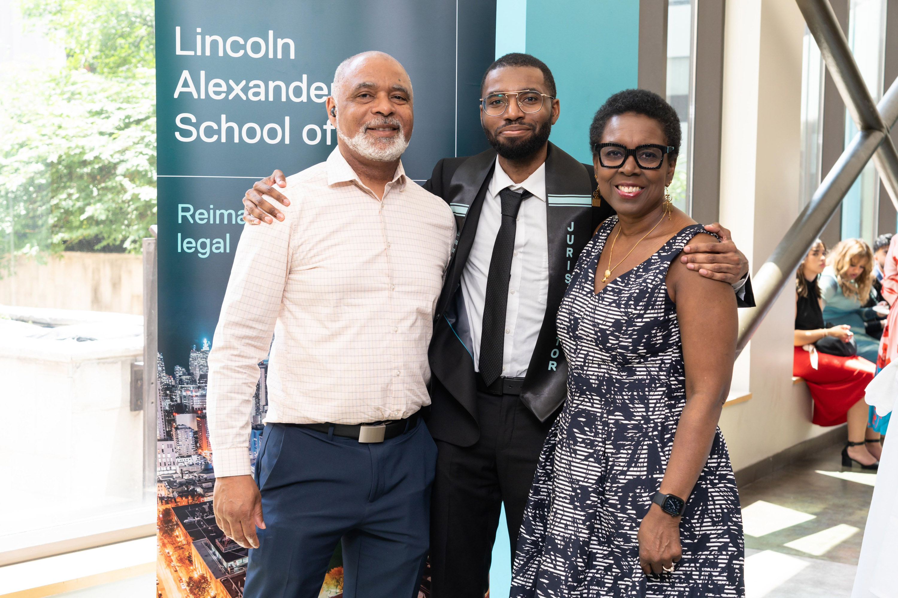 proud male grad posing with parents
