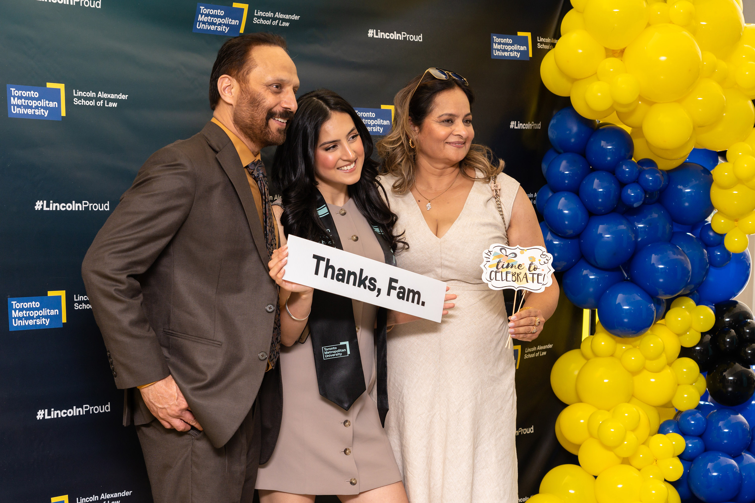 female grad with parents posing