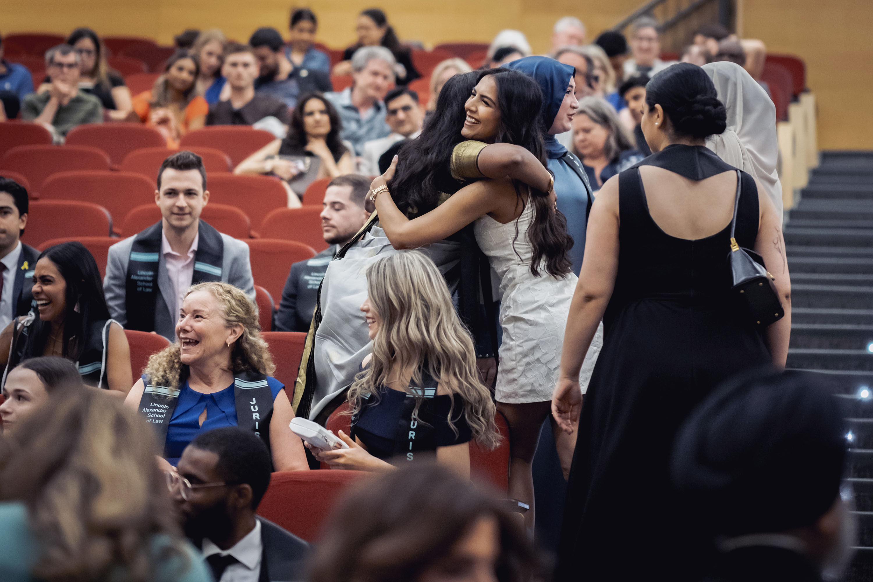 two students hugging in the auditorium