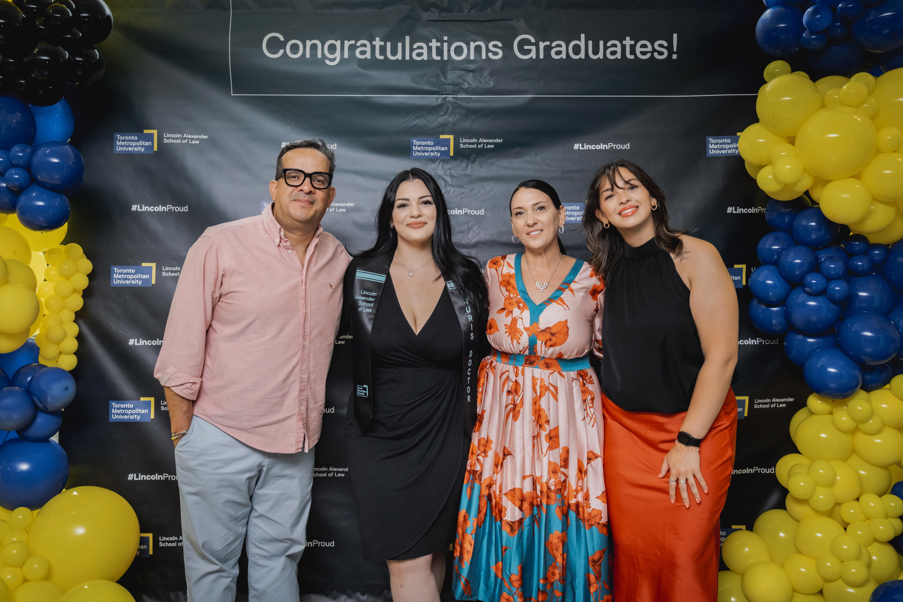 grad with family posing at balloons