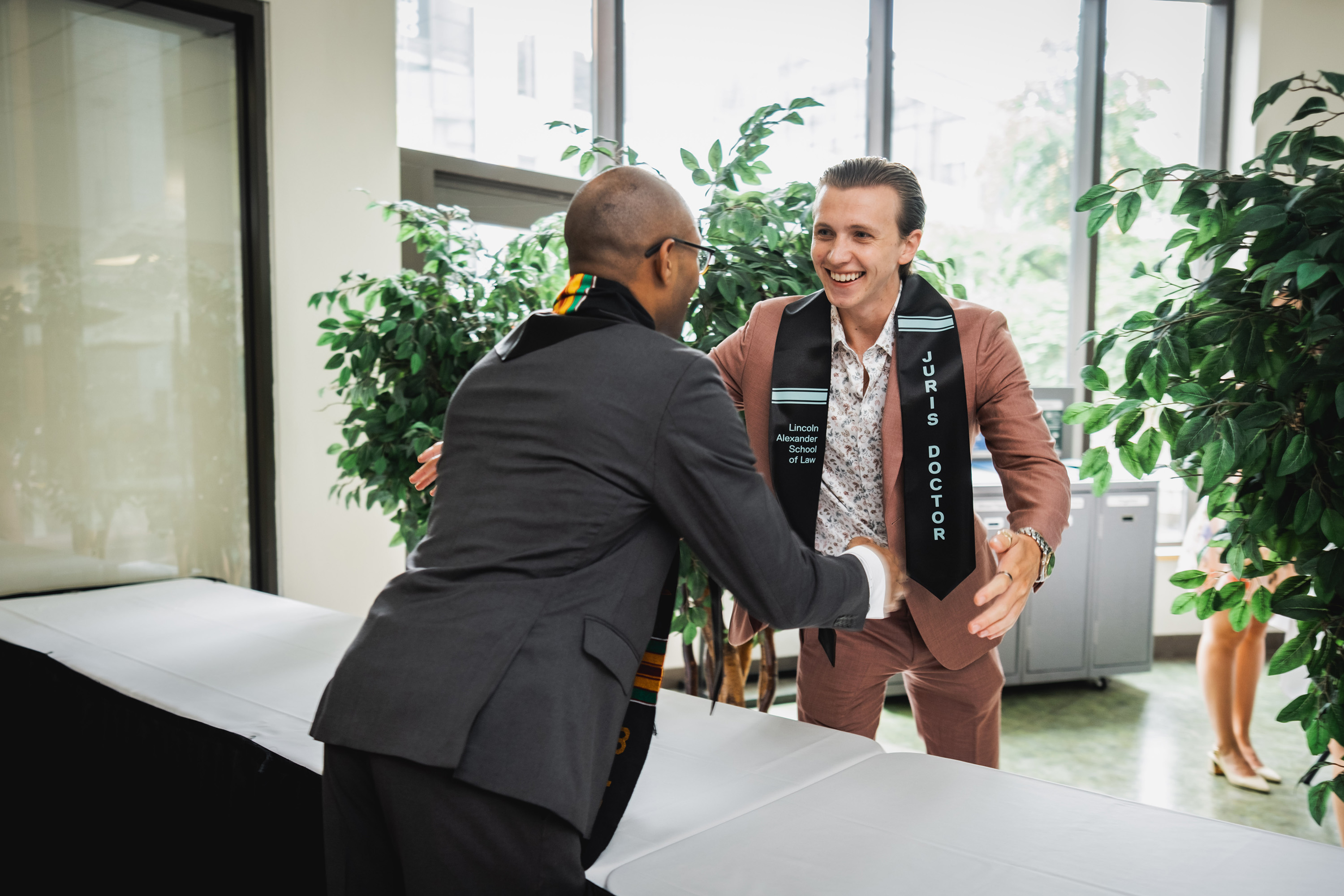 two grads greeting each other