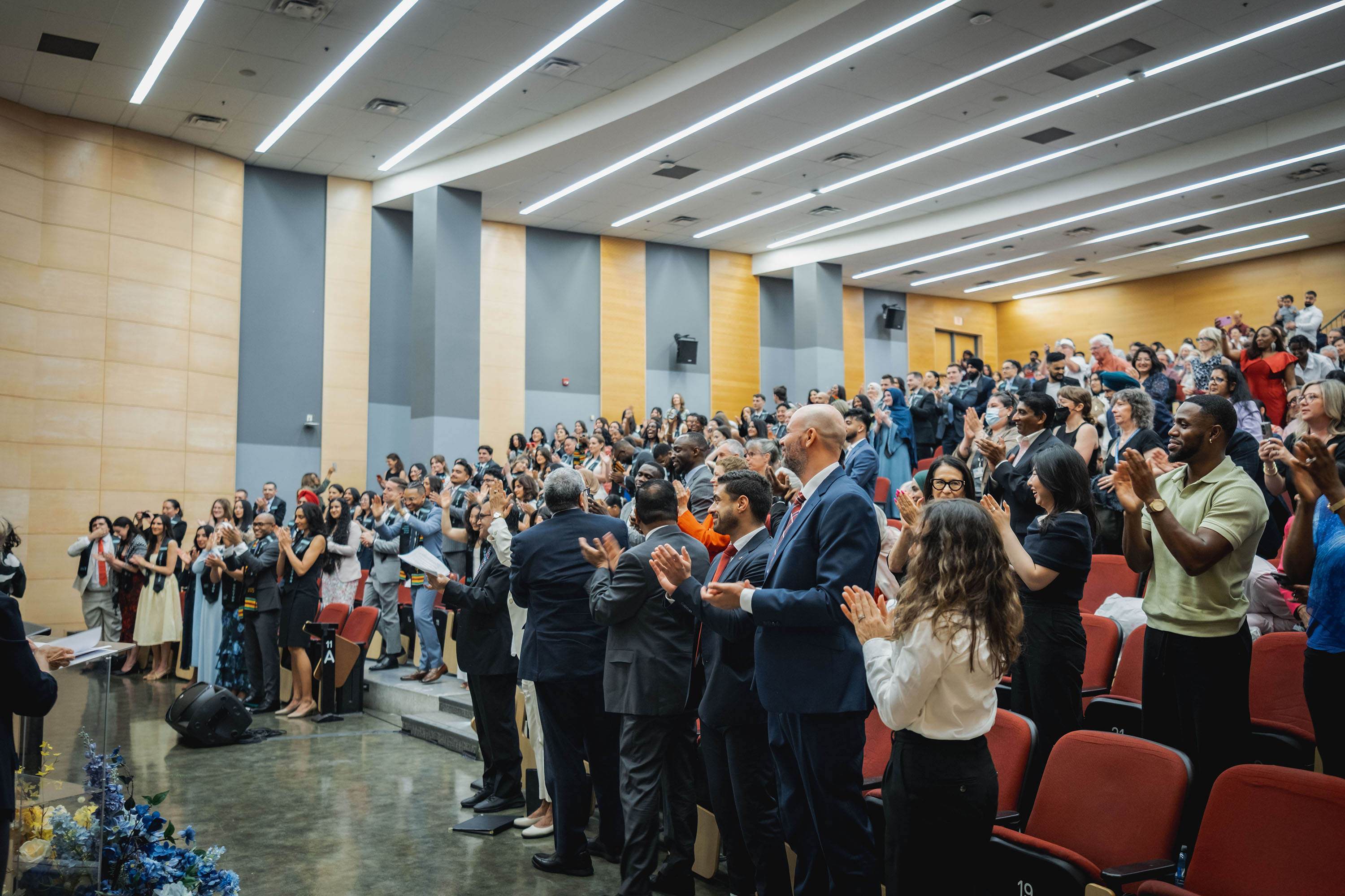 attendees standing and clapping in the auditorium