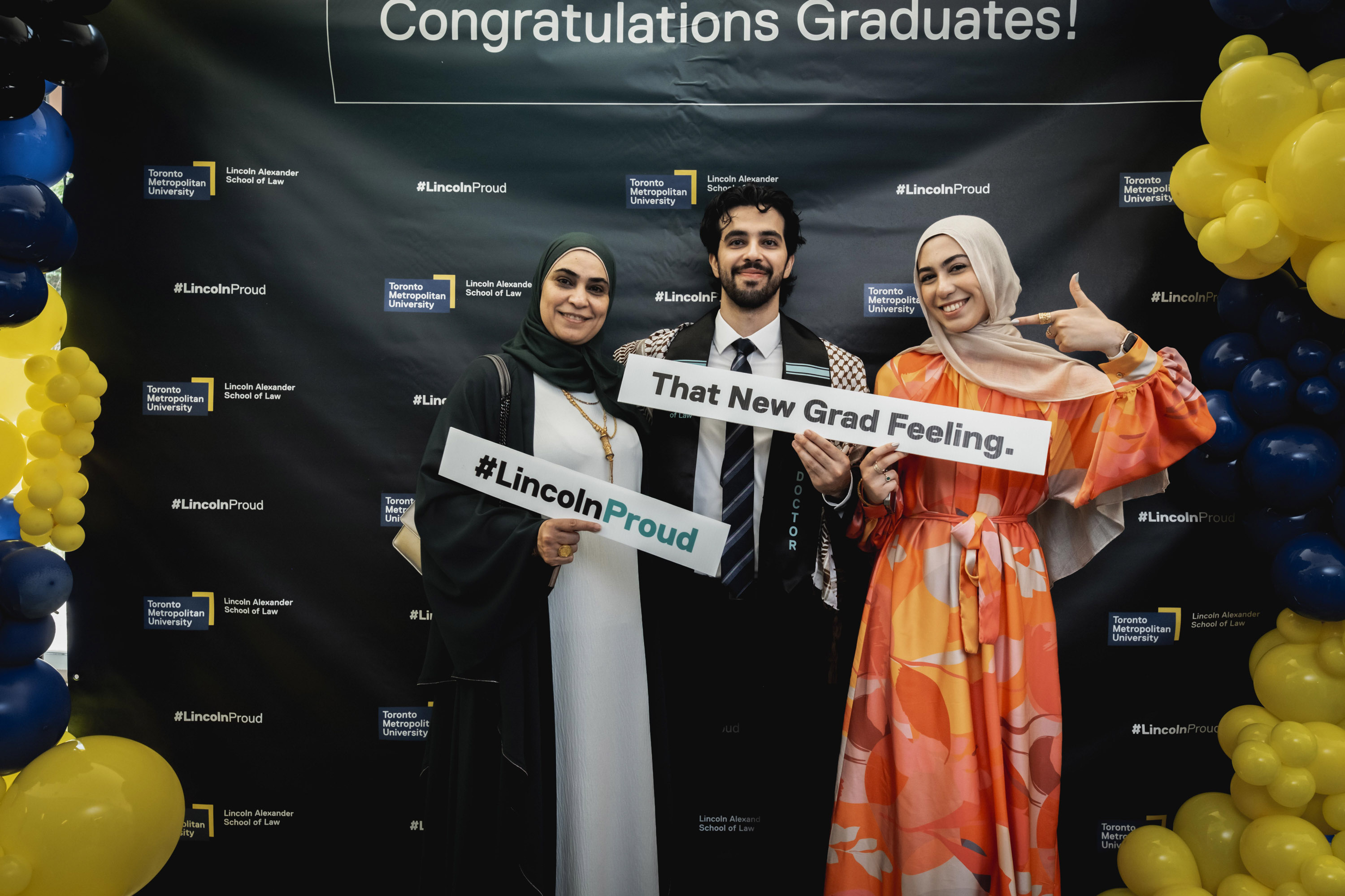 family with grad posing at balloons