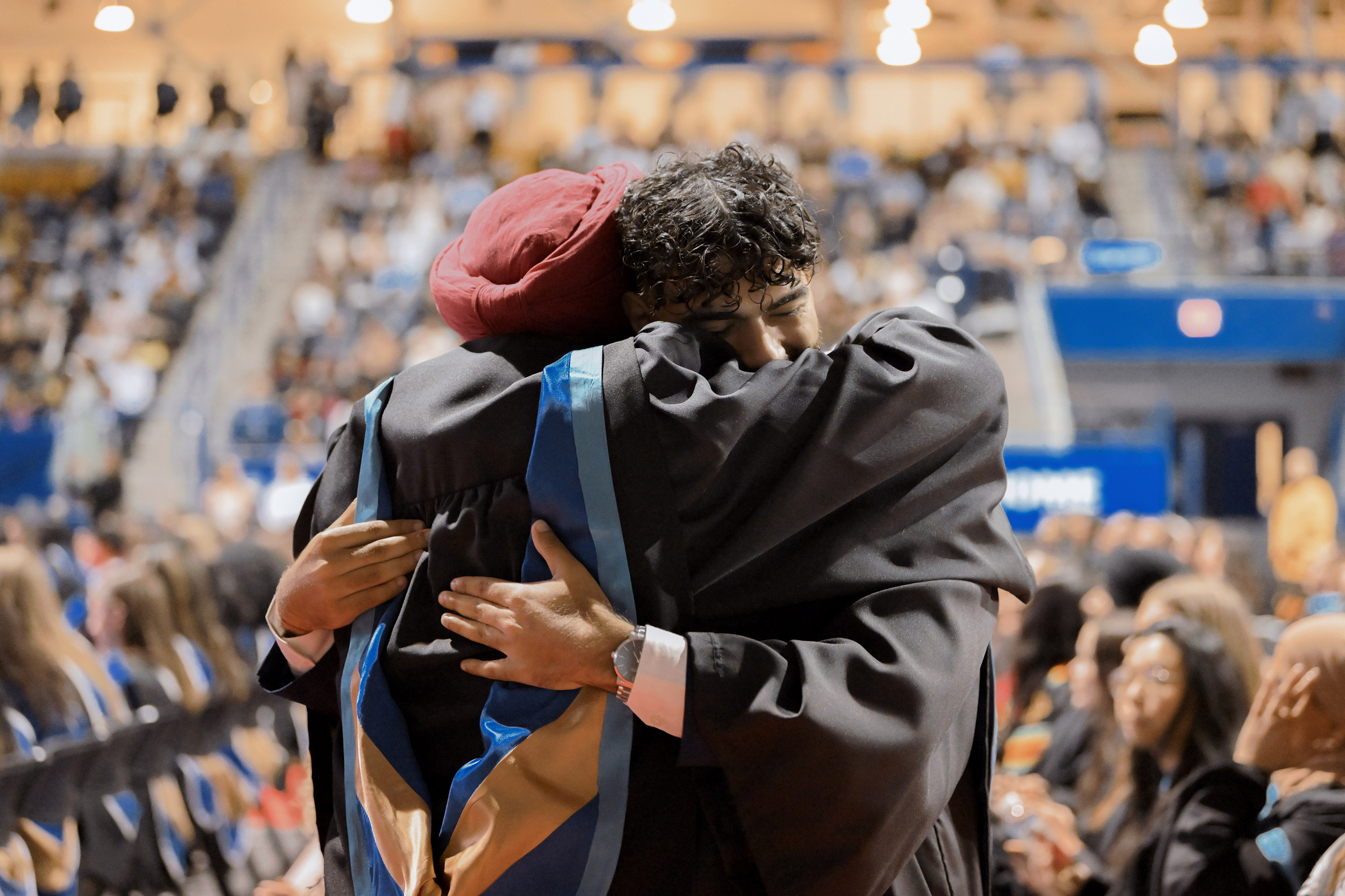 two grads embrace