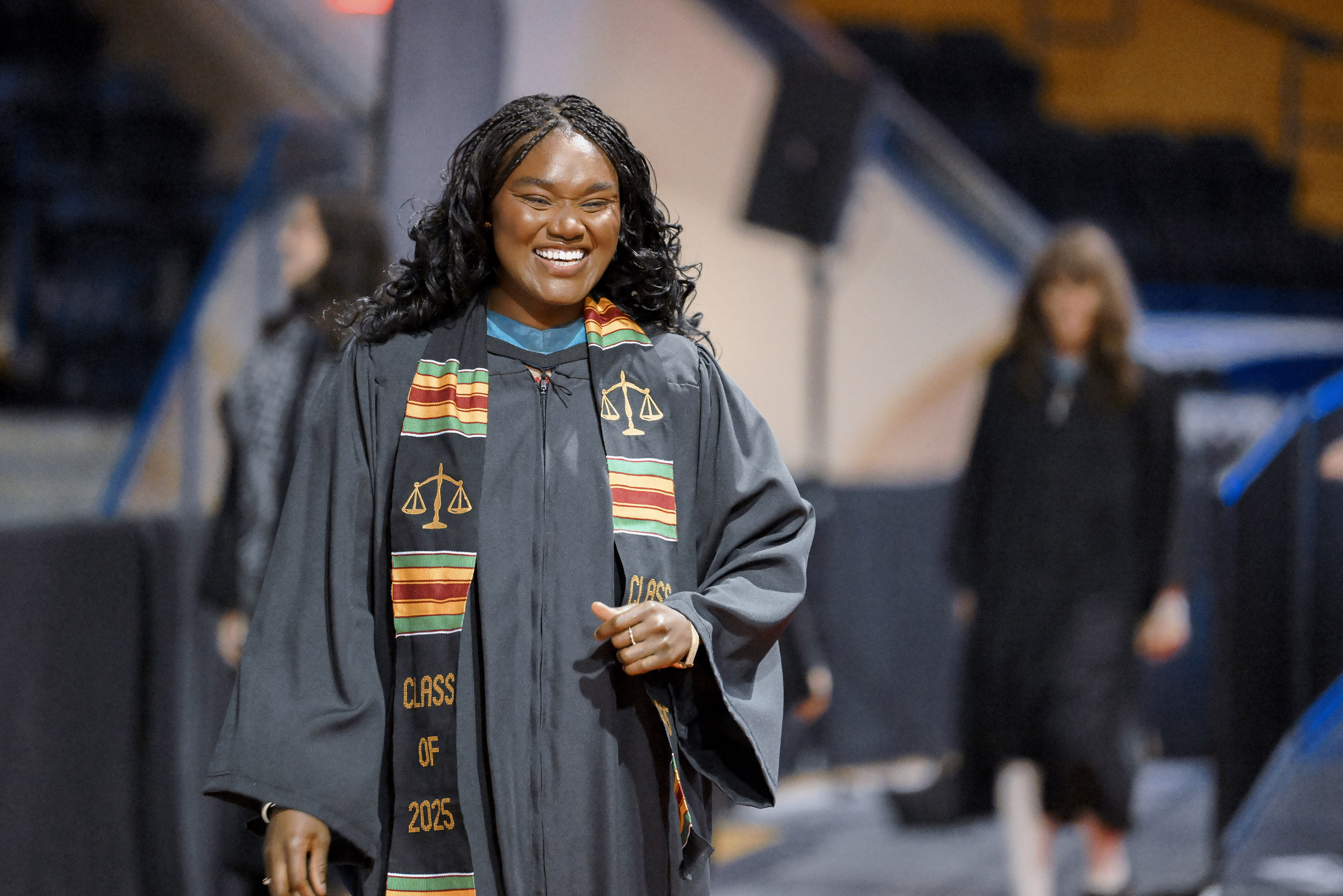 grad smiling as she walks from stage