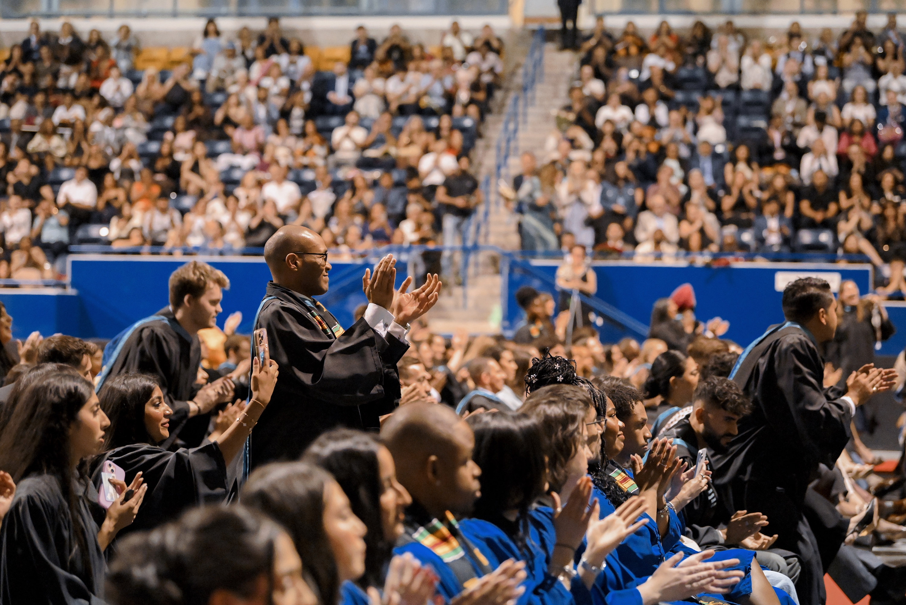 grads standing and cheering from audience