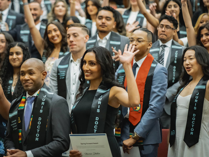 graduates waving in audience