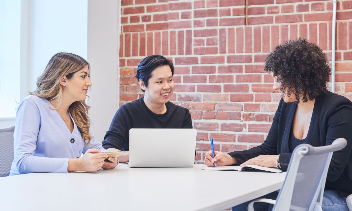 Three students working together at a laptop