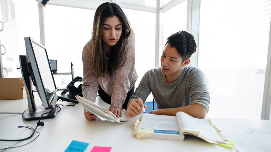 two students reading a textbook