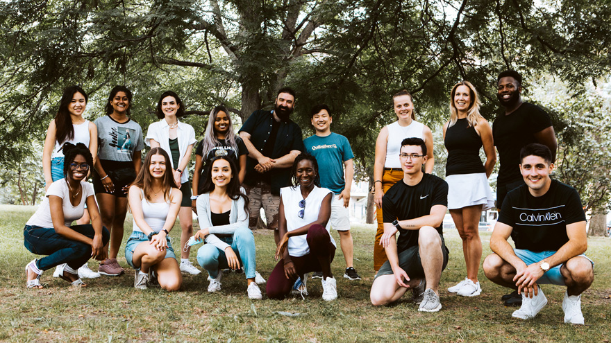 large group of students posing for group photo in a park