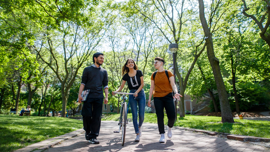 Students walking on campus with bike