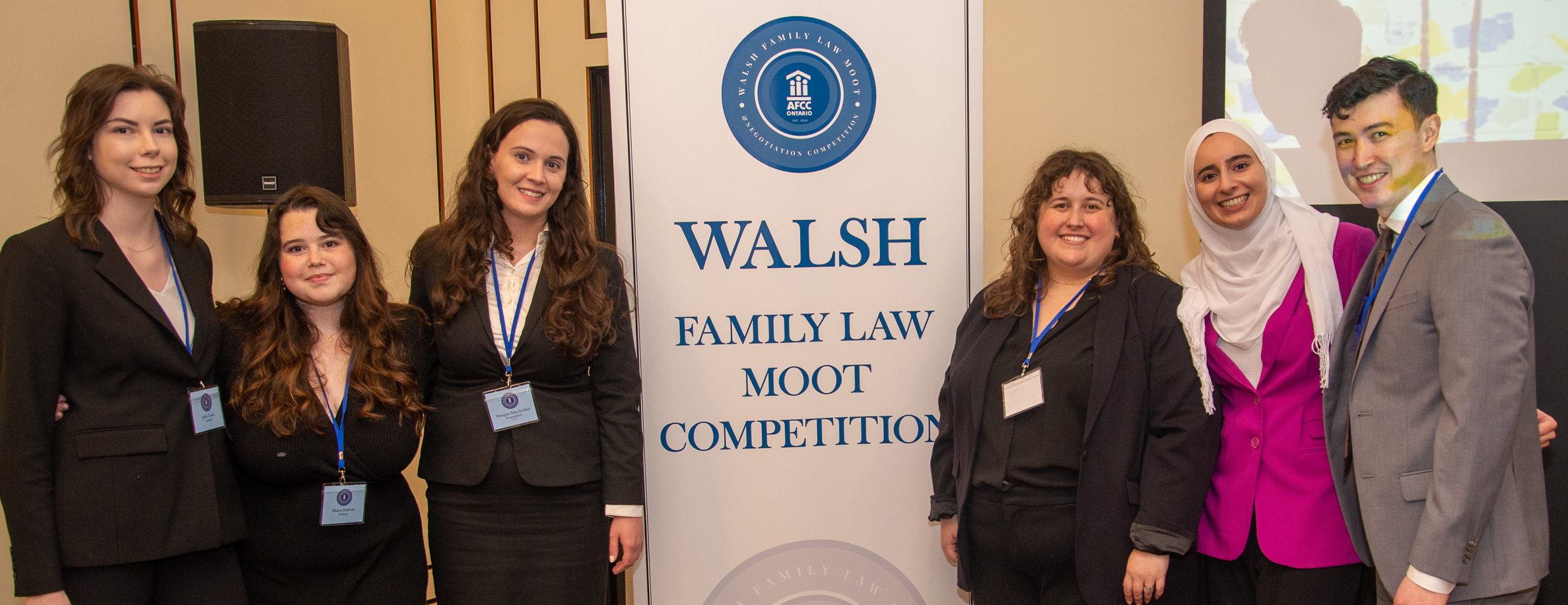 Student winners standing near the banner "Walsh Family Law Moot Competition"