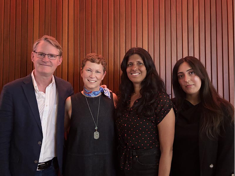 A group photo of Tod Augusta-Scott, Prof. Jennifer Orange, Attiya Khan, and Sabrina Khela posing in front of a wooden slatted wall
