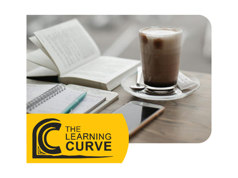 Desk with a notebook, textbook, coffee and phone