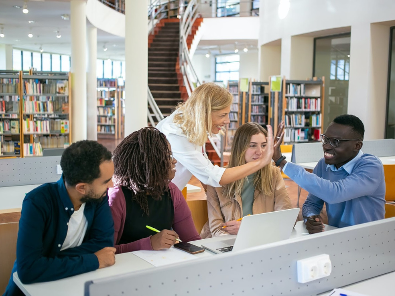 An instructor with students in a library.