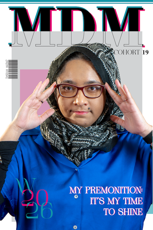 "A magazine-style portrait of Zaima Atoshi for MDM Cohort 19. She is wearing a bright blue button-up shirt and a black and white patterned hijab, posing with her hands near her red-rimmed glasses. The editorial layout includes grey and pink geometric blocks, large stylized 'MDM' text at the top, and 'W 2026' in the bottom left. White text on the right reads: 'MY PREMONITION: IT’S MY TIME TO SHINE.' Her name, Zaima Atoshi, is printed vertically on the left beside a barcode graphic."
