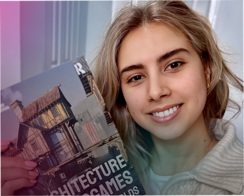 Nansy Khanano smiles while holding up a book titled Architecture and Videogames: Intersecting Worlds.