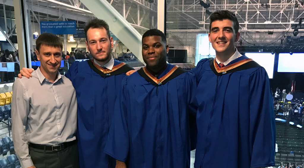 Mathematics BSc Graduates standing with their professor at convocation.