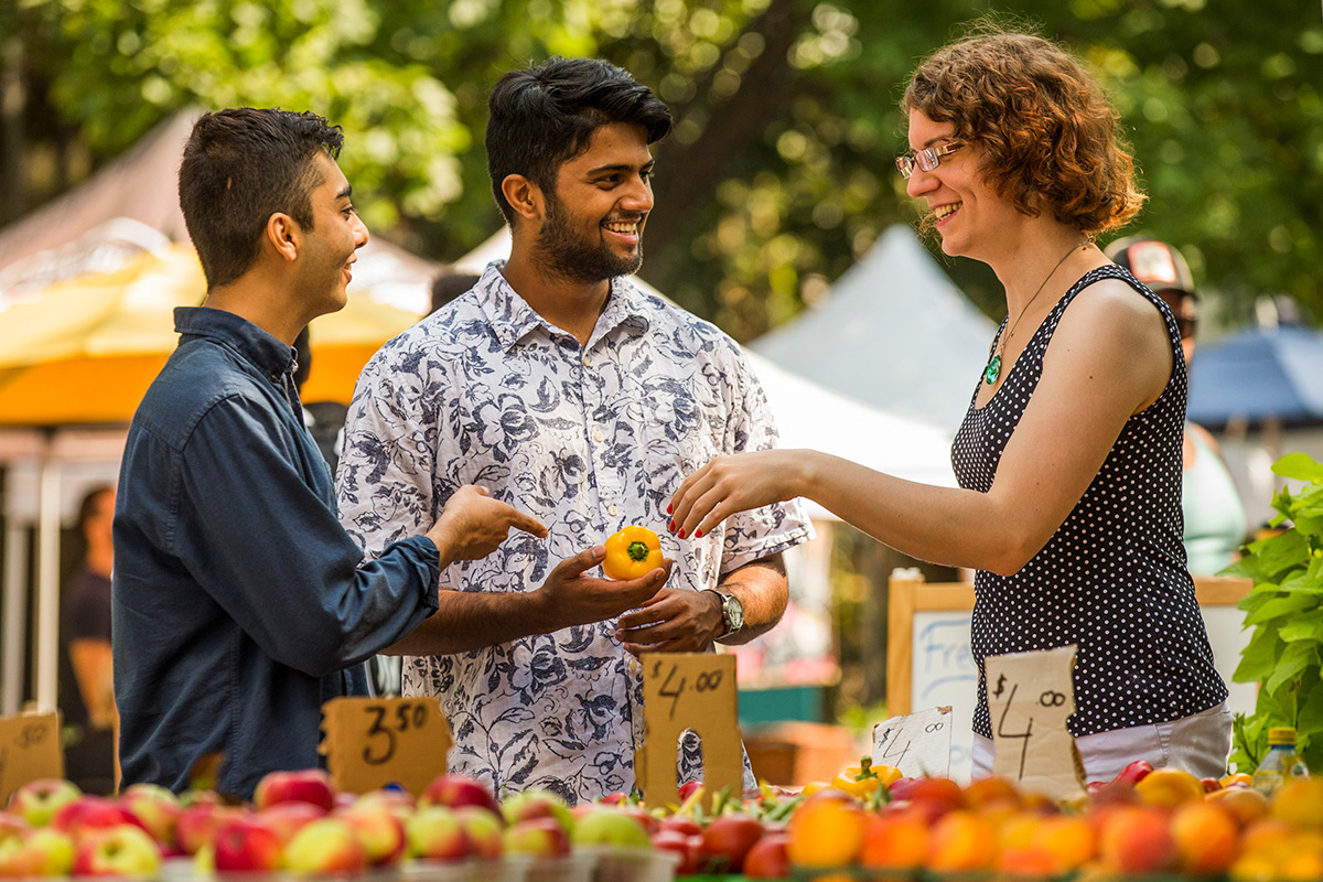 farmer's market vendor selling groceries to students