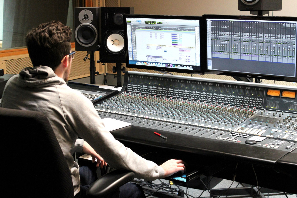 Student sitting at desk of a Media Production studio