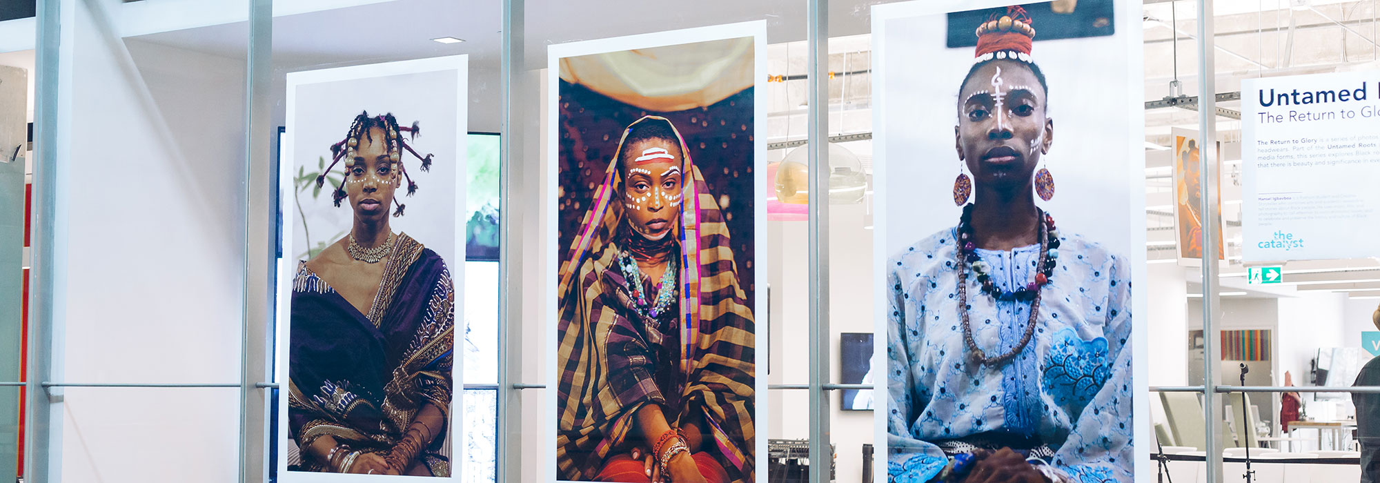 Enlarged photographic images of women in traditional dress mounted on a glass wall