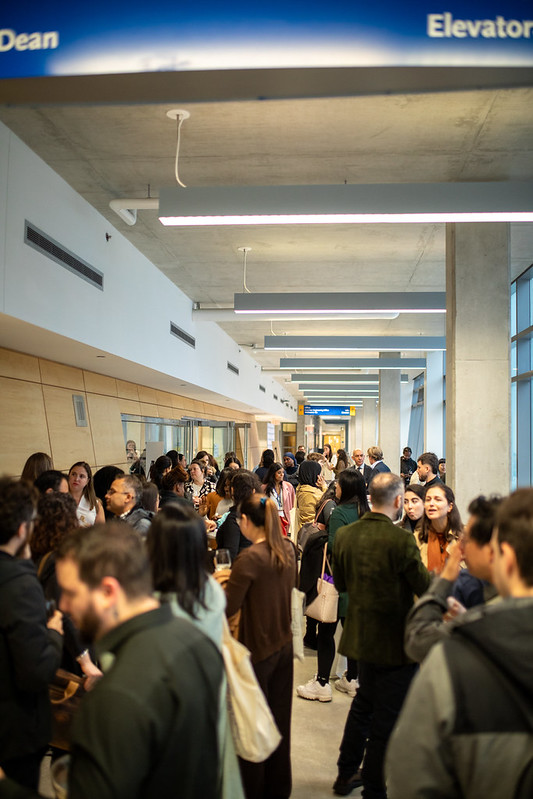 A hallway full of people standing and talking to eachother