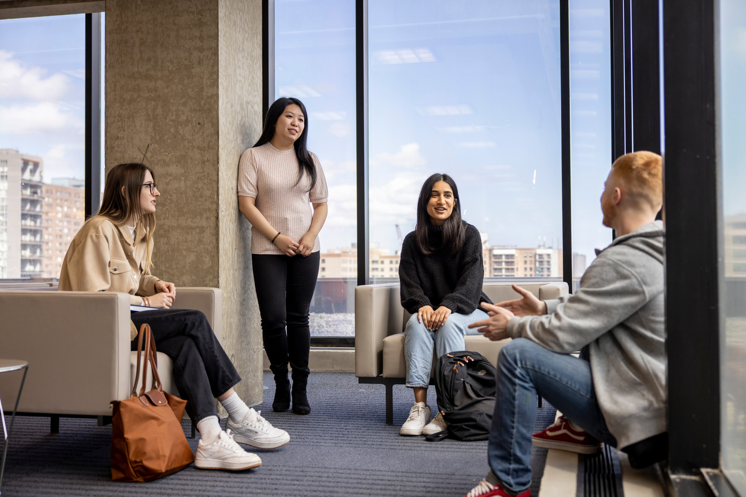 Four students enaged in conversation sitting in a circle