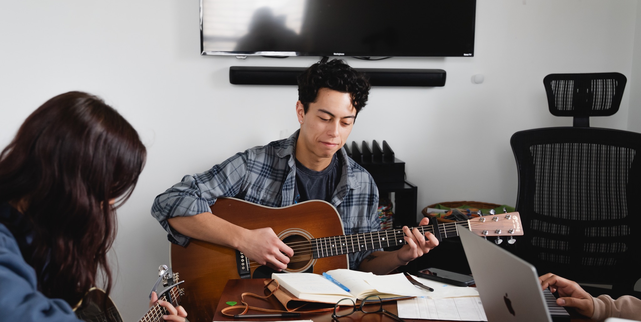 Students collaborate on a song, playing acoustic guitars together. Photo courtesy of Antonio Adams