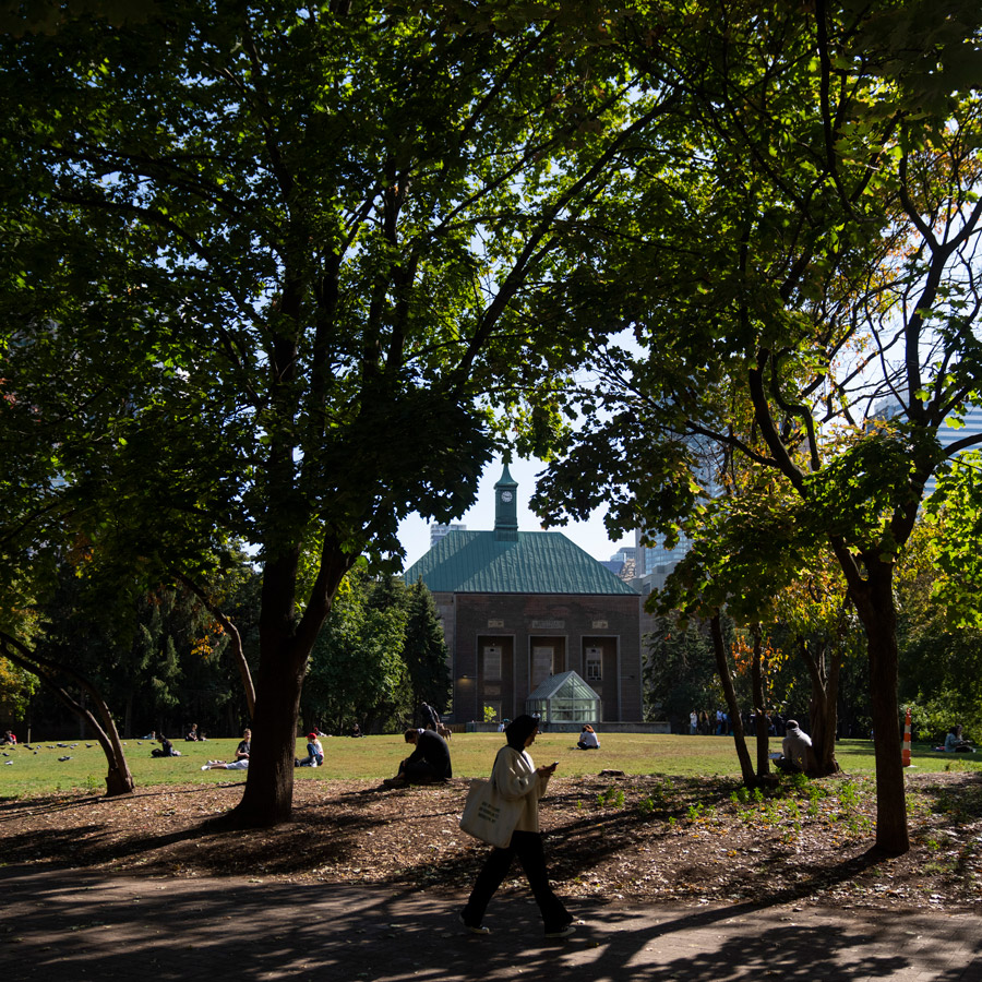 A student walks though the Quad, past the Kerr Hall clocktower on a sunny day.