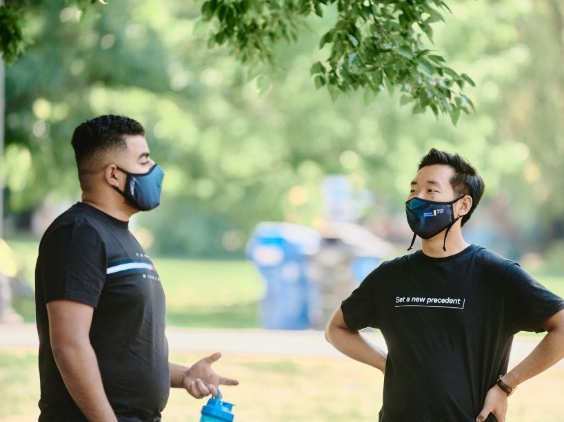 Two Orientation participants talking outside with masks.