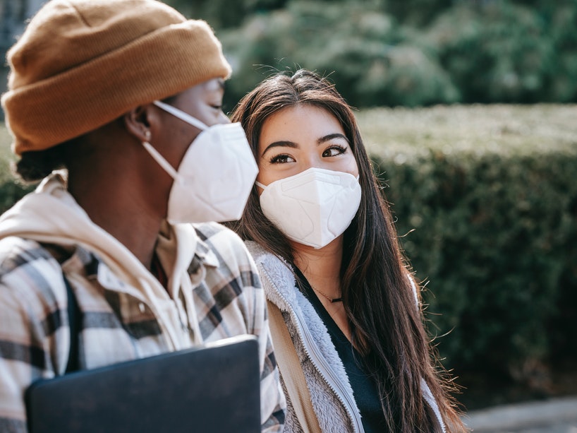 Two female students walk to class wearing masks.