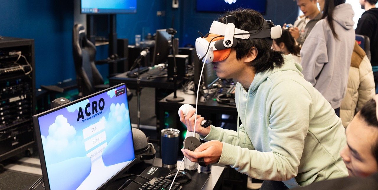 A student uses a Virtual Reality headset to play a video game in the Red Bull Gaming Hub