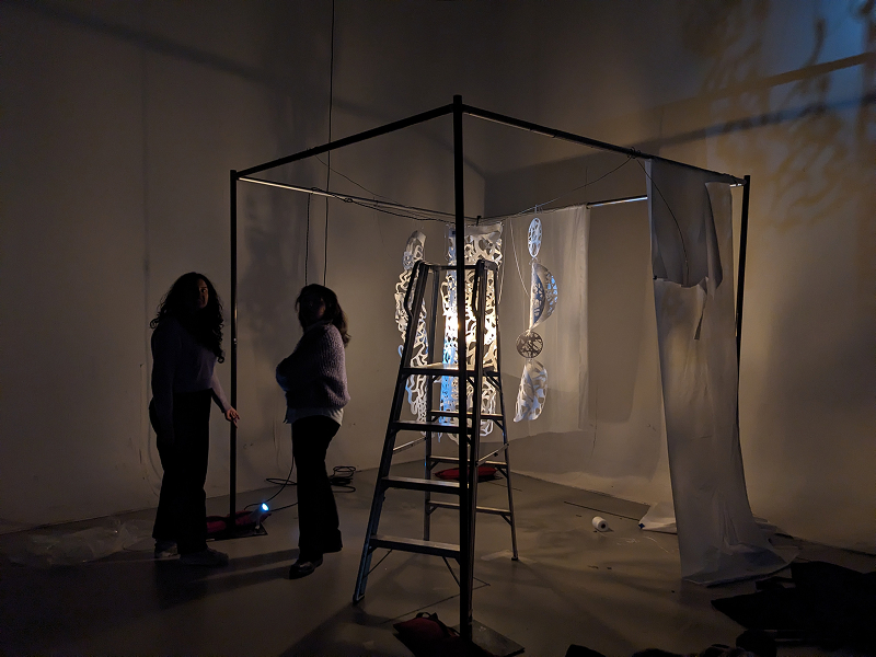 Students loading in an exhibition in a dimly lit museum space