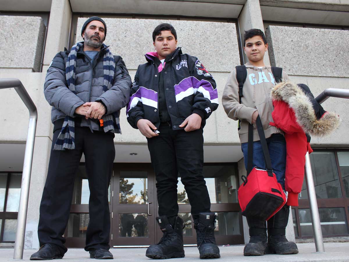 Mahmoud Al Rassoul standing with two sons