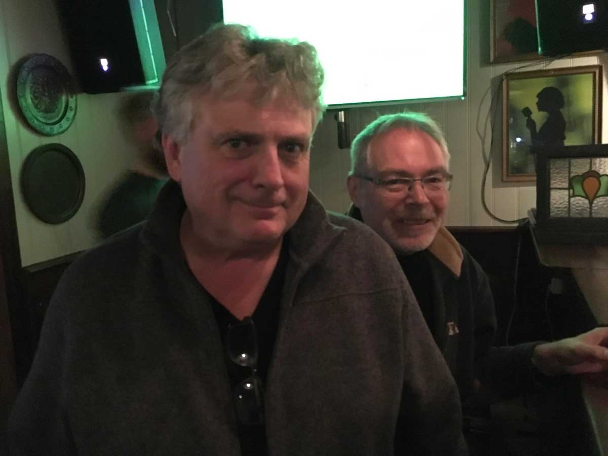 John Shields standing in front of Bryan Evans