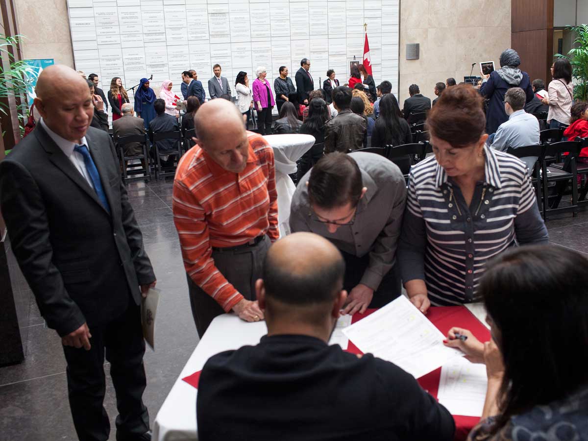 New citizens signing documents