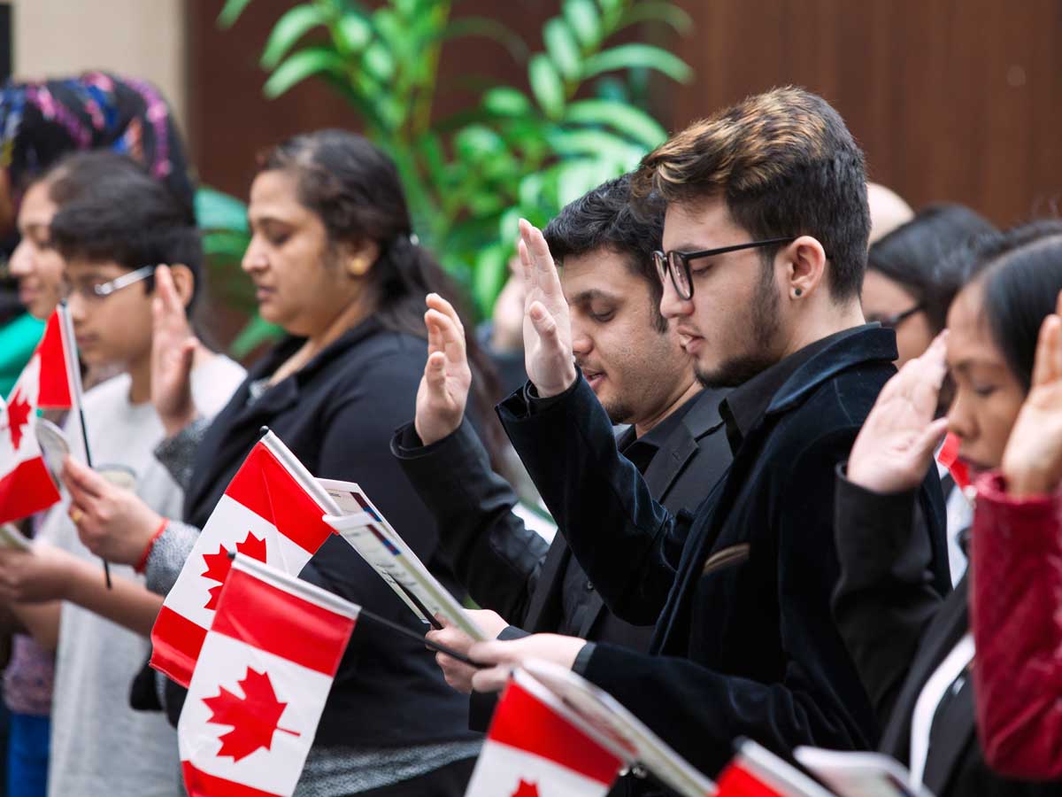 New Canadians taking the citizenship oath