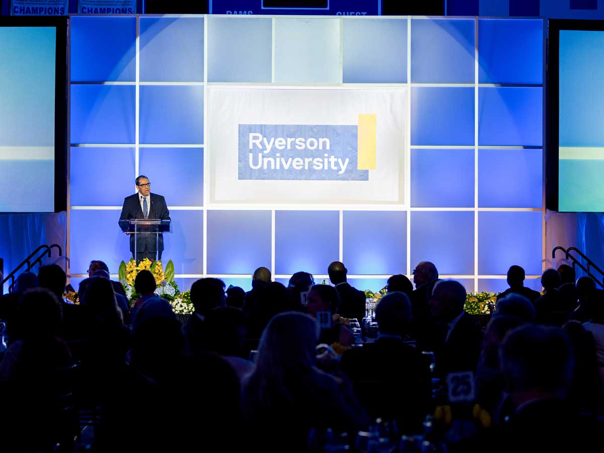 President Mohamed Lachemi talking at podium on stage