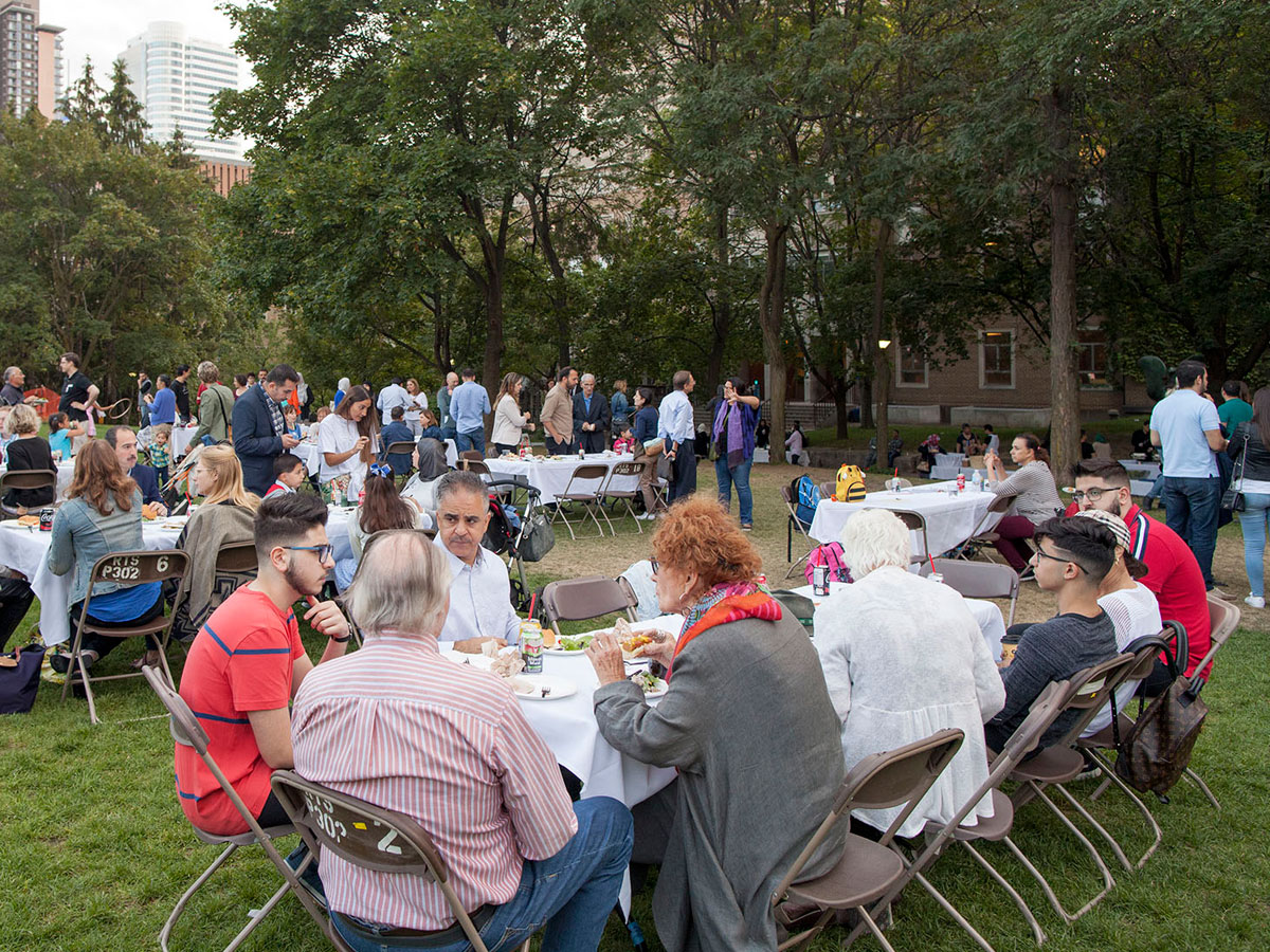 Families eating at picnic tables in the quad