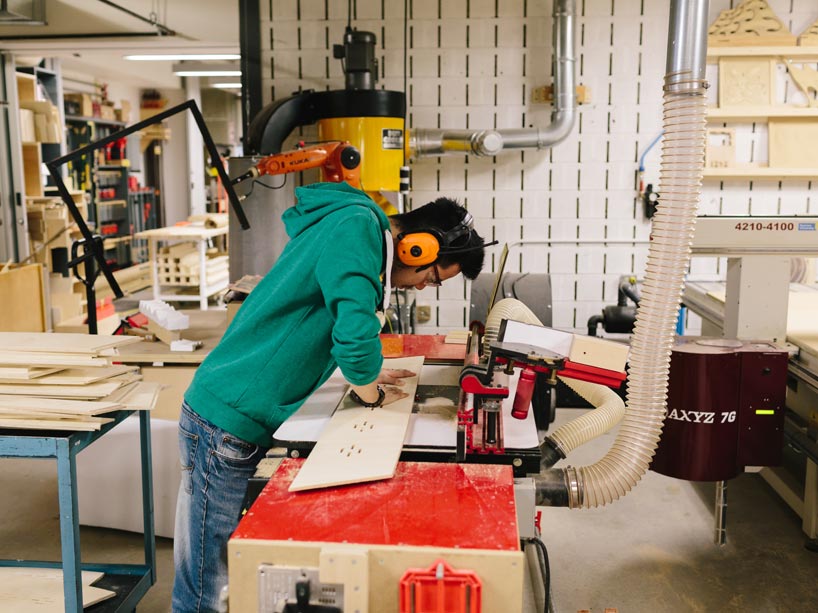 Student cutting plywood with machine
