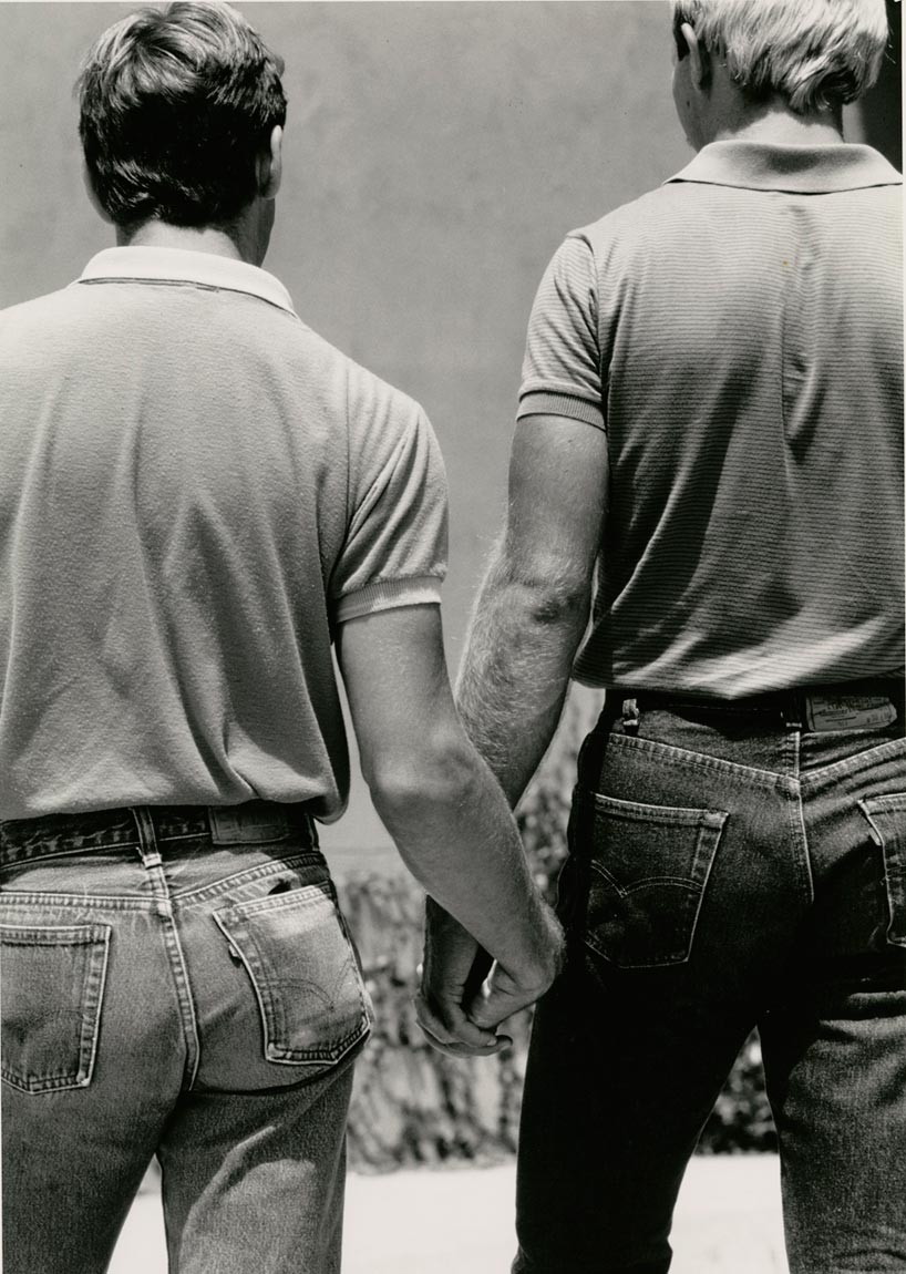 Black and white photo of two men holding hands