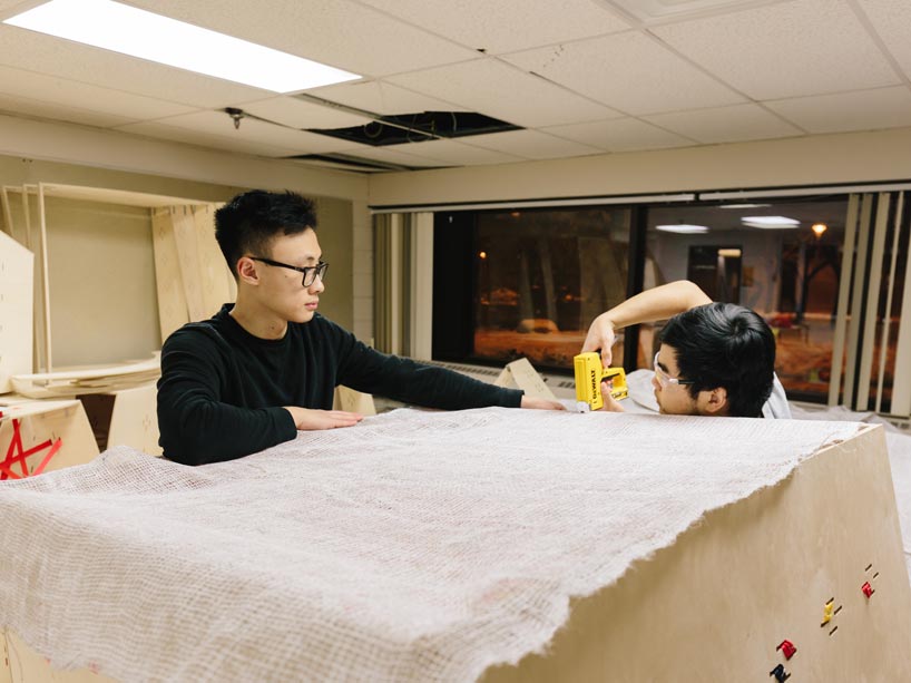 Students attaching burlap to plywood