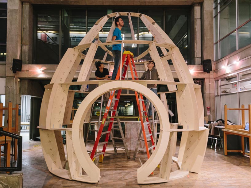 Students standing inside wood structure